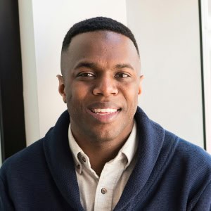 Smiling man in a blue pullover and white shirt